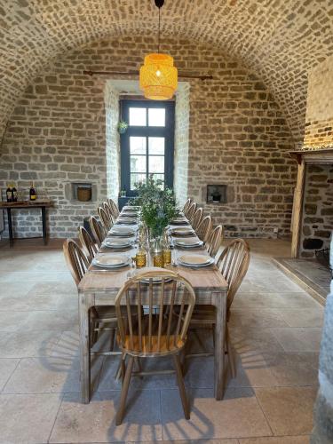 - une grande table en bois avec des chaises dans une pièce en briques dans l'établissement Saperlipopette charmante demeure en pierre de taille, à Baincthun