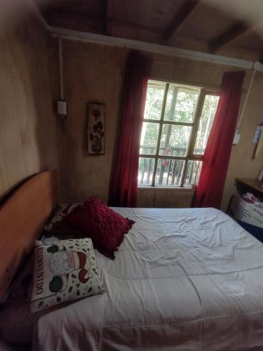 a bedroom with a white bed with a window at La recta del 14 in Agua Fría
