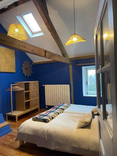 une chambre avec un grand lit aux murs bleus dans l'établissement Saperlipopette charmante demeure en pierre de taille, à Baincthun
