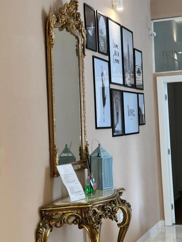 un espejo en una pared junto a una mesa en TIZIANA'S HOUSE, en Salerno