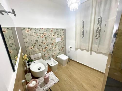 a bathroom with a toilet and a flower wallpaper at Da Zia Maria in Palermo
