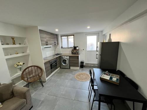 une cuisine et un salon avec un canapé et une table dans l'établissement Appartement en rez-de-jardin, à Vitry-sur-Seine