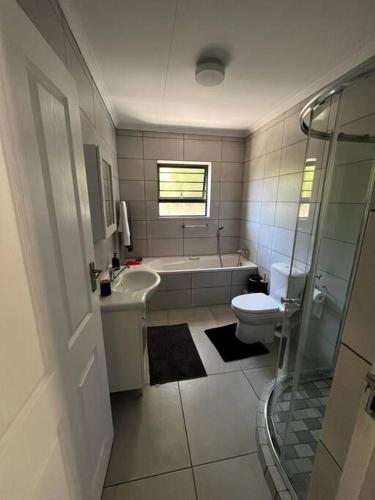 Un baño con bañera, lavabo e inodoro. en Protea Blossoms, en Ciudad del Cabo