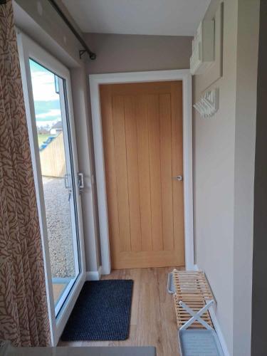 a door leading to a room with a balcony at Rowan Bank Retreat in Fort Augustus