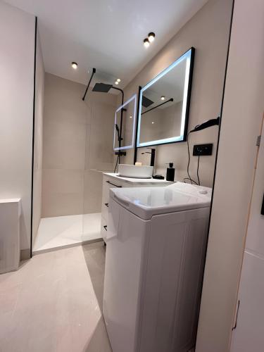 une salle de bain blanche avec un lavabo et un miroir dans l'établissement Vue Mont blanc, ski et village, à Combloux