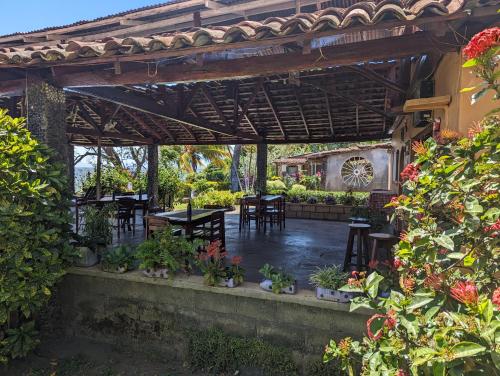 Hotel Playa Santa Martha في ريفاس: فناء في الهواء الطلق مع طاولات وكراسي ونباتات
