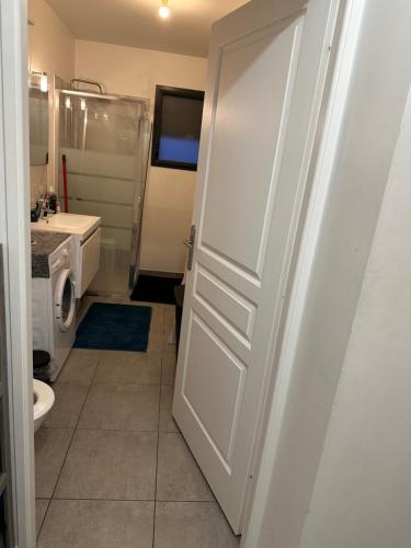 La salle de bains est pourvue de toilettes et d'une porte blanche. dans l'établissement L'appartement, à Tremblay-en-France