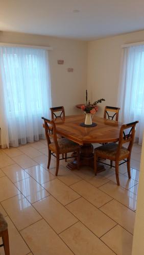 a dining room with a wooden table and chairs at Renovierte 4,5-Zi-Wohnung mit Parkplatz in ruhiger Lage - 90m2 in Wil
