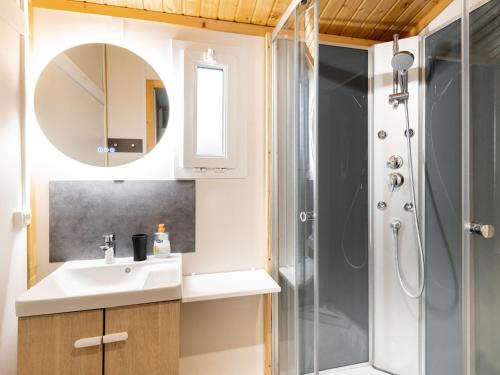 ein Bad mit einer Dusche, einem Waschbecken und einem Spiegel in der Unterkunft Cottage 5 personnes Bias Mimizan in Bias