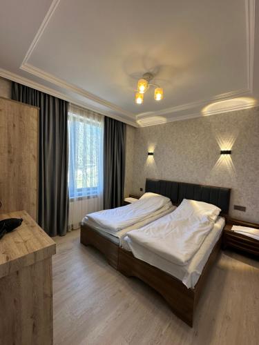 - une chambre avec un grand lit et des draps blancs dans l'établissement Pİrqulu Restaurant&Cottages, à Avaxıl