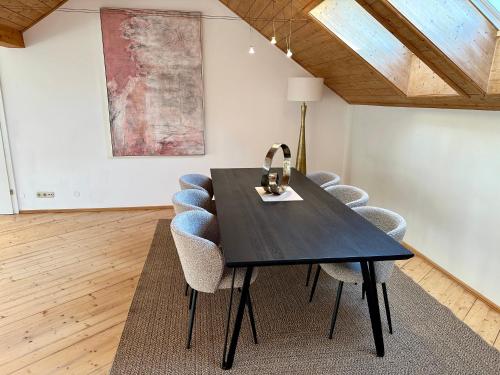 a dining room with a black table and chairs at 17er Apartment mit Sauna und privater Garage in Mondsee