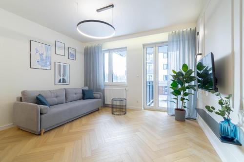 een woonkamer met een bank en een groot raam bij Blue Apartment Ceglana - FREE PARKING - Self check-in in Katowice