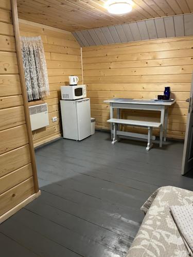 ein Zimmer mit einem Herd und einem Tisch in einer Hütte in der Unterkunft Sadyba Dana in Tatariw