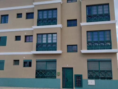 a building with green doors and windows at Apartamento Stefi in Arrecife