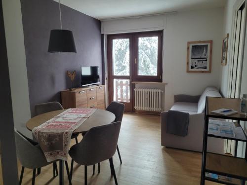 a living room with a table and chairs and a bedroom at Condominio Le Grange - Casa E in Sauze dʼOulx