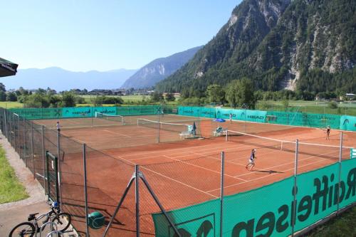 two tennis players are playing on a tennis court at Urban Alpine Penthouse with Lake View in Maurach