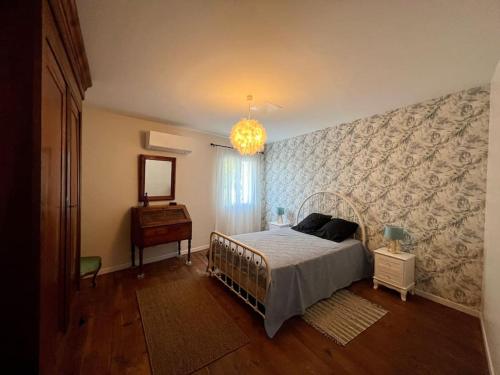 een slaapkamer met een bed, een spiegel en een dressoir bij MAS DE LA BOURIDE in Bellegarde
