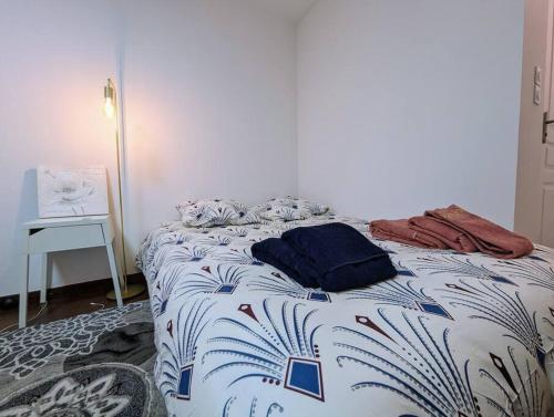 a bedroom with a bed with a blue and white blanket at Chez les P'tits loups in Strasbourg