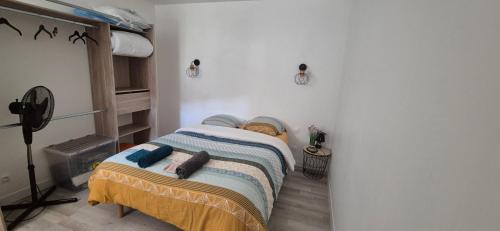 a small bedroom with a bed with a blanket at Le Cocon de Mila in Uzer