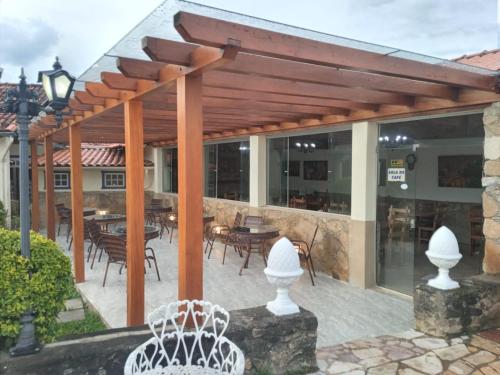 an outdoor patio with a wooden pergola at Pousada Berço da Liberdade in Tiradentes