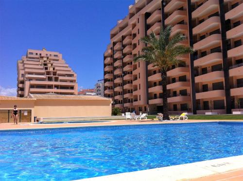 a swimming pool in front of two tall buildings at Portimão, Praia da Rocha in Portimão