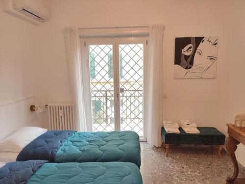 una camera con un letto blu e una finestra di Sunnyhome- Ostia Lido vista mare 2 bagni a Lido di Ostia