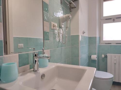 uma casa de banho com um lavatório branco e um WC. em Sunnyhome- Ostia Lido vista mare 2 bagni em Lido di Ostia