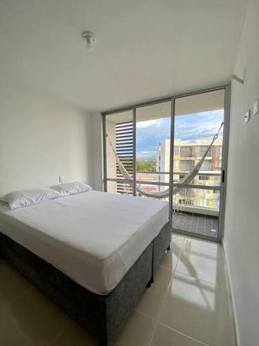 a large bed in a room with a large window at Apartamento de descanso in Ricaurte