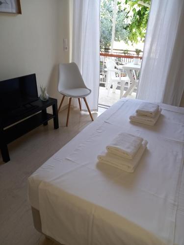 1 dormitorio con 1 cama con 2 toallas en ΝΑRIKA, en Kamena Vourla