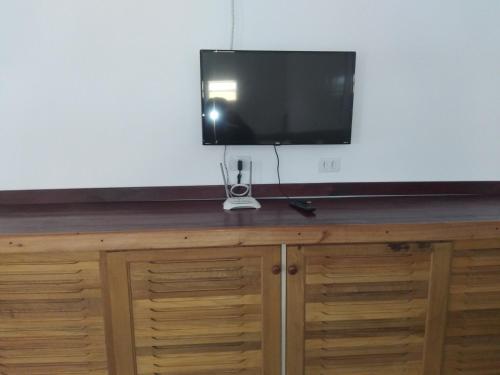 TV de pantalla plana en la parte superior de un armario de madera en casa de praia en Guaratuba