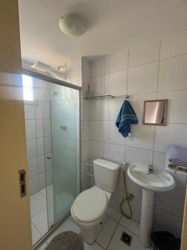 a bathroom with a toilet and a sink and a shower at Mar de Aruana - Apartamento Suíte com Ar Aracaju-SE in Aracaju