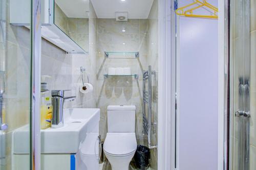 a bathroom with a toilet and a sink and a shower at Streatley Apartments in London