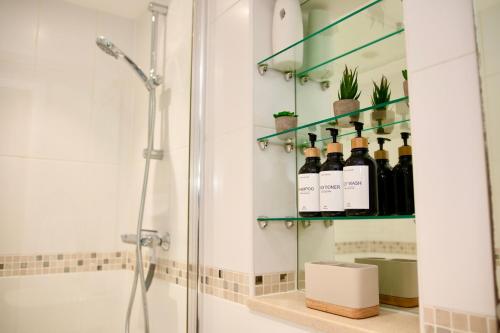 ein Bad mit einer Dusche und Weinflaschen in der Unterkunft Modern Flat in Sheffield, South Yorkshire in Sheffield