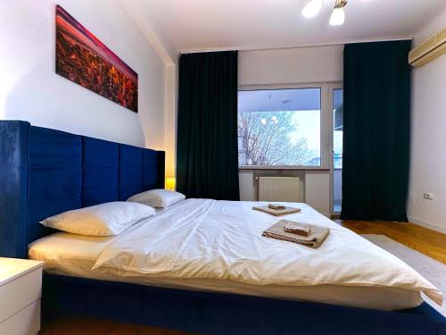 um quarto com uma cama grande, uma cabeceira azul e uma janela. em Ultracentral Apartment 4 rooms - Old City Center -120 square meters - em Bucareste