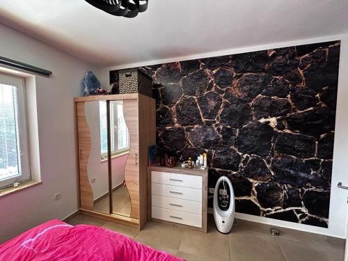 een slaapkamer met een rotswand met een spiegel bij Vila Emily in Peruški