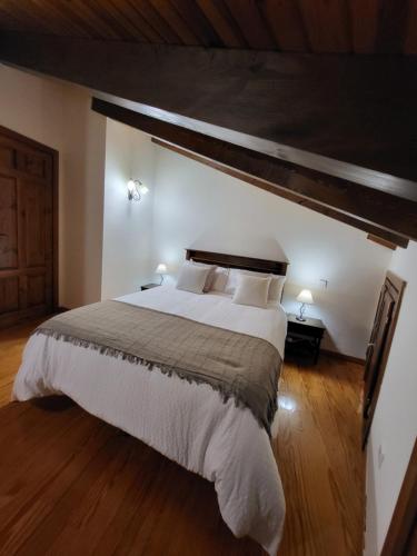 a bedroom with a large bed and a wooden floor at El Refugio de Gredos in Guisando