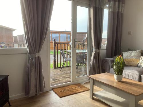 a living room with a sliding glass door at J16 Mablethorpe Pet Friendly Chalet in Mablethorpe