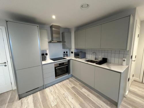 an empty kitchen with white cabinets and appliances at 2 Bed 2 Bath in Digbeth in Birmingham