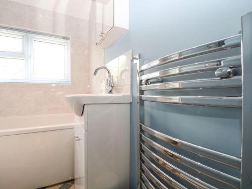 a bathroom with a sink and a refrigerator at Charming Country Cottage in Selborne