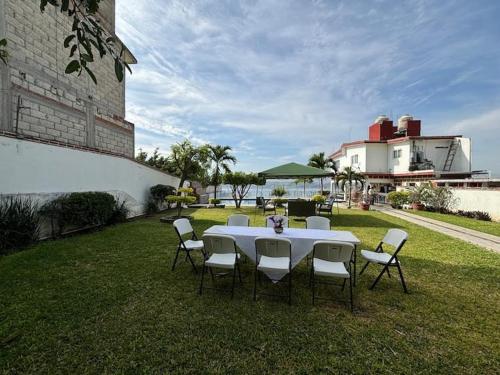 a white table and chairs sitting on the grass at Terraza del Lago in Tequesquitengo