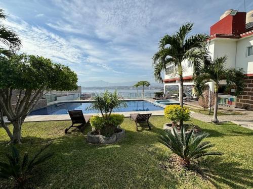 a yard with two chairs and a swimming pool at Terraza del Lago in Tequesquitengo
