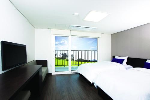 um quarto de hotel com duas camas e uma grande janela em Hanwha Resort Yongin Besancon em Yongin