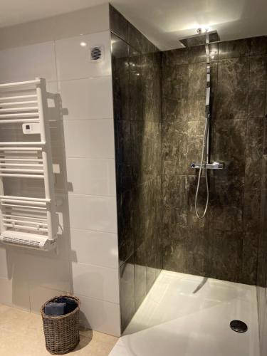 a shower with a glass door in a bathroom at « La Crécerelle » spacieux gîte contemporain entre Tarn et Aveyron in Sainte-Gemme
