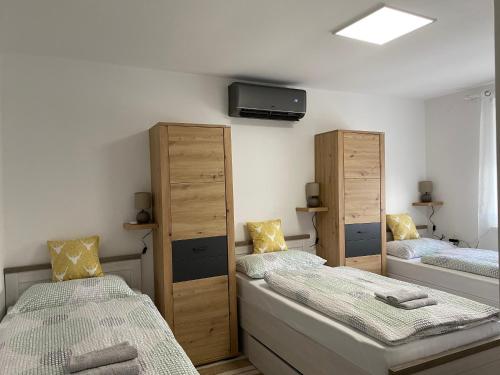 a bedroom with two beds and a tv on the wall at Kuća za odmor Erdelji in Vardarac