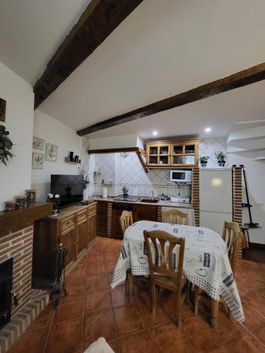 a kitchen with a table and a kitchen with a stove at El Refugio de Gredos in Guisando
