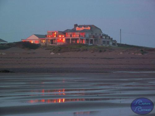 a house on the beach with its lights on at Beach House B&B in Bude