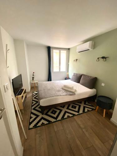 une chambre avec un grand lit et une télévision dans l'établissement Lapromenadesete, à Sète