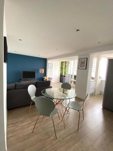 un salon avec une table en verre et des chaises dans l'établissement Lapromenadesete, à Sète