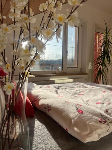 a bedroom with a bed with a vase of flowers at Podkrovní apartmán s balkónem in Ostrava