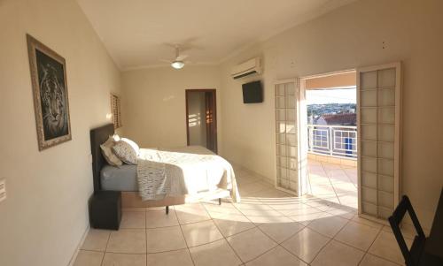 um quarto com uma cama e uma porta de vidro deslizante em Repouso Real Rio Preto em Sao Jose do Rio Preto